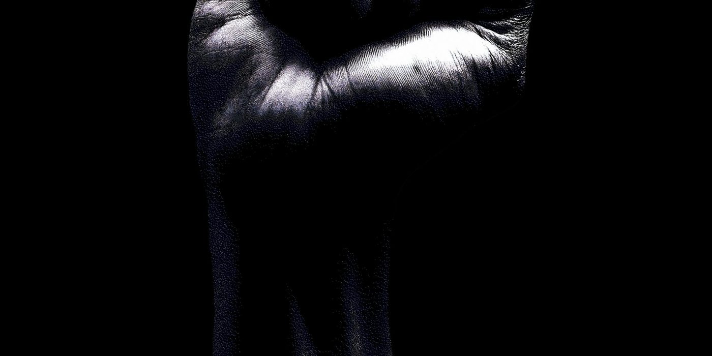 Erhobene Faust vor dunklem Hintergrund als Symbol für Stärke und Selbstbehauptung.